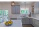 Well-lit kitchen with gray cabinets, white countertops, undermount sink, and sliding door to deck at 5163 S River Rd, Lillington, NC 27546