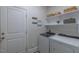 Bright laundry room with washer, dryer, storage shelves, and white door at 5163 S River Rd, Lillington, NC 27546