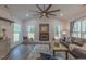 Inviting living room featuring a cozy fireplace, a large ceiling fan, and lots of windows at 5163 S River Rd, Lillington, NC 27546