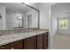 Bathroom showcasing a granite-topped vanity, a large mirror, and an open doorway to the bedroom at 531 N Person St # 205, Raleigh, NC 27604