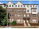 Attractive brick townhome with a covered entryway, manicured landscaping, and gray shingle siding on the upper floors at 531 N Person St # 205, Raleigh, NC 27604