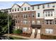 Attractive brick townhome with a covered entryway, manicured landscaping, and gray shingle siding on the upper floors at 531 N Person St # 205, Raleigh, NC 27604