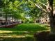 Exterior shot of manicured green space surrounded by trees and townhomes that invites outdoor enjoyment at 531 N Person St # 205, Raleigh, NC 27604