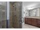 Elegant tiled shower with glass door with chrome hardware and a view of the granite-countered vanity at 531 N Person St # 205, Raleigh, NC 27604