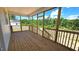 Inviting screened porch with wood flooring and railing, offering views of the surrounding greenery at 55 Stream View Way, Spring Hope, NC 27882