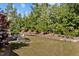 Expansive backyard featuring manicured lawn, landscaped garden beds, and a charming outdoor seating area at 623 Westfall Way, Chapel Hill, NC 27517