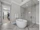 Bright bathroom featuring a soaking tub, glass shower and herringbone tile flooring at 623 Westfall Way, Chapel Hill, NC 27517