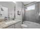 Bathroom showcasing granite countertop on white cabinets, tub with glass door, and gray tiled walls at 623 Westfall Way, Chapel Hill, NC 27517