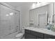 Bright bathroom featuring white subway tiles in shower, glass door, and granite countertop on gray cabinets at 623 Westfall Way, Chapel Hill, NC 27517