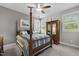 Bedroom with four-poster bed, ceiling fan, striped bedding, natural light, and wooden armoire at 623 Westfall Way, Chapel Hill, NC 27517