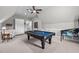Large, vaulted game room with pool table, pinball machine, storage cabinets, and neutral carpet at 623 Westfall Way, Chapel Hill, NC 27517