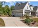 Attached two-car garage with a modern door, complemented by professional landscaping and a long driveway at 623 Westfall Way, Chapel Hill, NC 27517