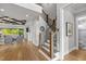 Hallway featuring hardwood floors, staircase, and access to living room with coffered ceilings at 623 Westfall Way, Chapel Hill, NC 27517