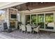 Covered outdoor patio with a ceiling fan, stone fireplace, TV, and dining table for luxury and comfort at 623 Westfall Way, Chapel Hill, NC 27517