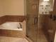 Well-lit bathroom features a large soaking tub, a glass-enclosed shower, and tiled walls at 631 Springfork Dr, Cary, NC 27513