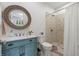 Well-appointed bathroom with blue vanity, round mirror, and a mosaic tile shower at 6500 Bass Mountain Rd, Snow Camp, NC 27349