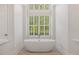 Modern bathroom with a standalone tub, large windows with plantation shutters, and neutral tones at 6500 Bass Mountain Rd, Snow Camp, NC 27349