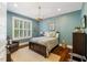Comfortable bedroom with blue walls, shuttered windows, and hardwood floors at 6500 Bass Mountain Rd, Snow Camp, NC 27349