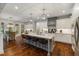 Spacious kitchen with white cabinets, gray island, stone countertops, and stainless-steel appliances at 6500 Bass Mountain Rd, Snow Camp, NC 27349