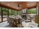 Relax on this screened porch featuring a stone fireplace, ceiling fan, and comfortable seating at 6500 Bass Mountain Rd, Snow Camp, NC 27349