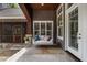 Covered porch with hanging swing and comfortable cushions, perfect for enjoying the outdoors at 6500 Bass Mountain Rd, Snow Camp, NC 27349