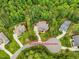 Aerial view of home on a wooded lot and a circular driveway, surrounded by lush greenery at 67 Spring Hollow Ct, Pittsboro, NC 27312