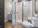 Bathroom featuring a tiled walk-in shower with glass door, vanity with storage, and wood-look tile flooring at 67 Spring Hollow Ct, Pittsboro, NC 27312