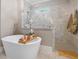 Bathroom features a freestanding tub, a frameless glass shower, and neutral tile at 67 Spring Hollow Ct, Pittsboro, NC 27312
