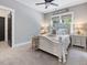 Bright bedroom featuring a beautifully decorated bed with soft pillows and a decorative ceiling fan at 67 Spring Hollow Ct, Pittsboro, NC 27312