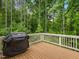 Outdoor deck with grill overlooking lush landscaping, ideal for outdoor cooking and relaxation at 67 Spring Hollow Ct, Pittsboro, NC 27312