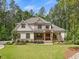 Charming two-story home featuring manicured landscaping and a welcoming front porch with rustic wood columns at 67 Spring Hollow Ct, Pittsboro, NC 27312