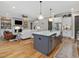 Open-concept living room and kitchen with hardwood floors, fireplace, and an island with marble countertop at 67 Spring Hollow Ct, Pittsboro, NC 27312