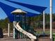 Community playground featuring a blue shade structure and a slide for children to play on at 67 Spring Hollow Ct, Pittsboro, NC 27312