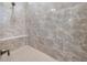 Modern bathroom shower featuring stylish stone-look tile surround and built in bench seat at 67 Spring Hollow Ct, Pittsboro, NC 27312