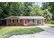 Charming single-story home with a brick facade, a red door, and a well-maintained front lawn at 7216 Carlton Dr, Raleigh, NC 27616