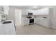 Modern kitchen with white shaker cabinets, stainless steel appliances, and quartz countertops at 7216 Carlton Dr, Raleigh, NC 27616