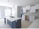Bright kitchen features white cabinets, an island with a sink, and quartz countertops at 788 Shade Tree Rd, Benson, NC 27504