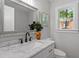Bathroom featuring a new vanity with marble countertop, stylish faucet, and decor, along with a gray tiled wall at 833 Brigham Rd, Raleigh, NC 27610