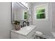 Newly remodeled bathroom featuring a quartz countertop, matte black faucet, and a modern tiled shower at 833 Brigham Rd, Raleigh, NC 27610
