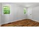 Sunlit bedroom boasts refinished hardwood floors, neutral walls, and windows showcasing the lush greenery outside at 833 Brigham Rd, Raleigh, NC 27610