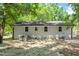 Exterior view of the rear of the home with white painted brick and windows that bring the outside in at 833 Brigham Rd, Raleigh, NC 27610