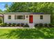Charming single-story home with a bright red front door and well-manicured landscaping at 833 Brigham Rd, Raleigh, NC 27610