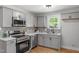 Stylish kitchen with gray cabinets, quartz countertops, and stainless steel appliances at 833 Brigham Rd, Raleigh, NC 27610