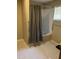 Clean bathroom with shower-tub combo, light tan walls, vinyl tile floors, safety grab bars, and window blinds at 836 S Main St, Roxboro, NC 27573