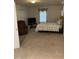 Carpeted bedroom with natural light, a queen bed with quilted blanket, brown recliner, and a TV on a stand at 836 S Main St, Roxboro, NC 27573