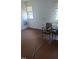 Spacious living room with wood floors, white walls, and two windows at 836 S Main St, Roxboro, NC 27573
