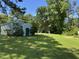 View of a well-maintained backyard and storage shed, surrounded by lush green trees and grass at 8405 Falcon Crest Cir, Angier, NC 27501