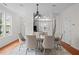 Open-concept dining area featuring a large table, six chairs, and elegant chandelier with hardwood flooring at 100 Stratford Lakes Dr # 270, Durham, NC 27713