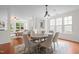 Bright dining area featuring a large table, six chairs, and elegant chandelier with hardwood flooring at 100 Stratford Lakes Dr # 270, Durham, NC 27713