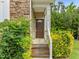 Inviting front entrance showcasing stone accents, a wooden door, steps and vibrant landscaping at 100 Stratford Lakes Dr # 270, Durham, NC 27713